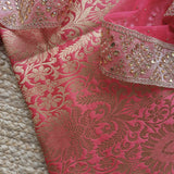 Women’s festive brocade suit set with pink red tones and decorative kundan border detailing