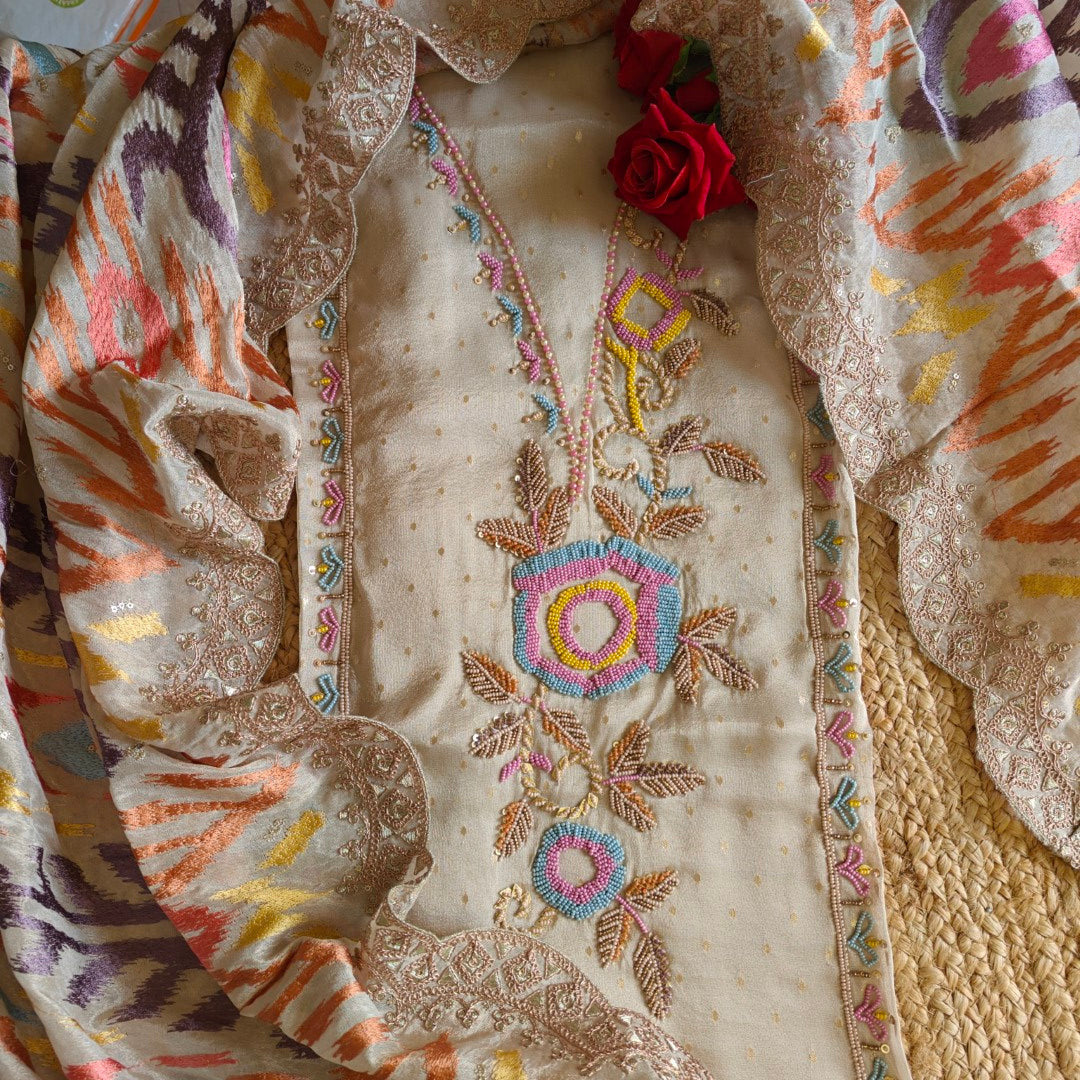 Close-up of an embroidered fabric with floral patterns and colorful borders.