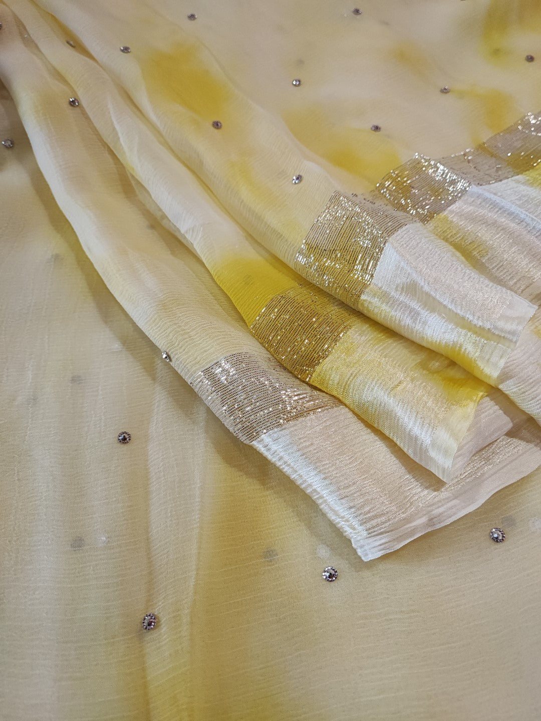 Yellow Chiffon saree with silver Zari border.