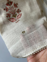 Women’s light cream salwar suit material featuring lightweight mul linen texture and festive printed detailing