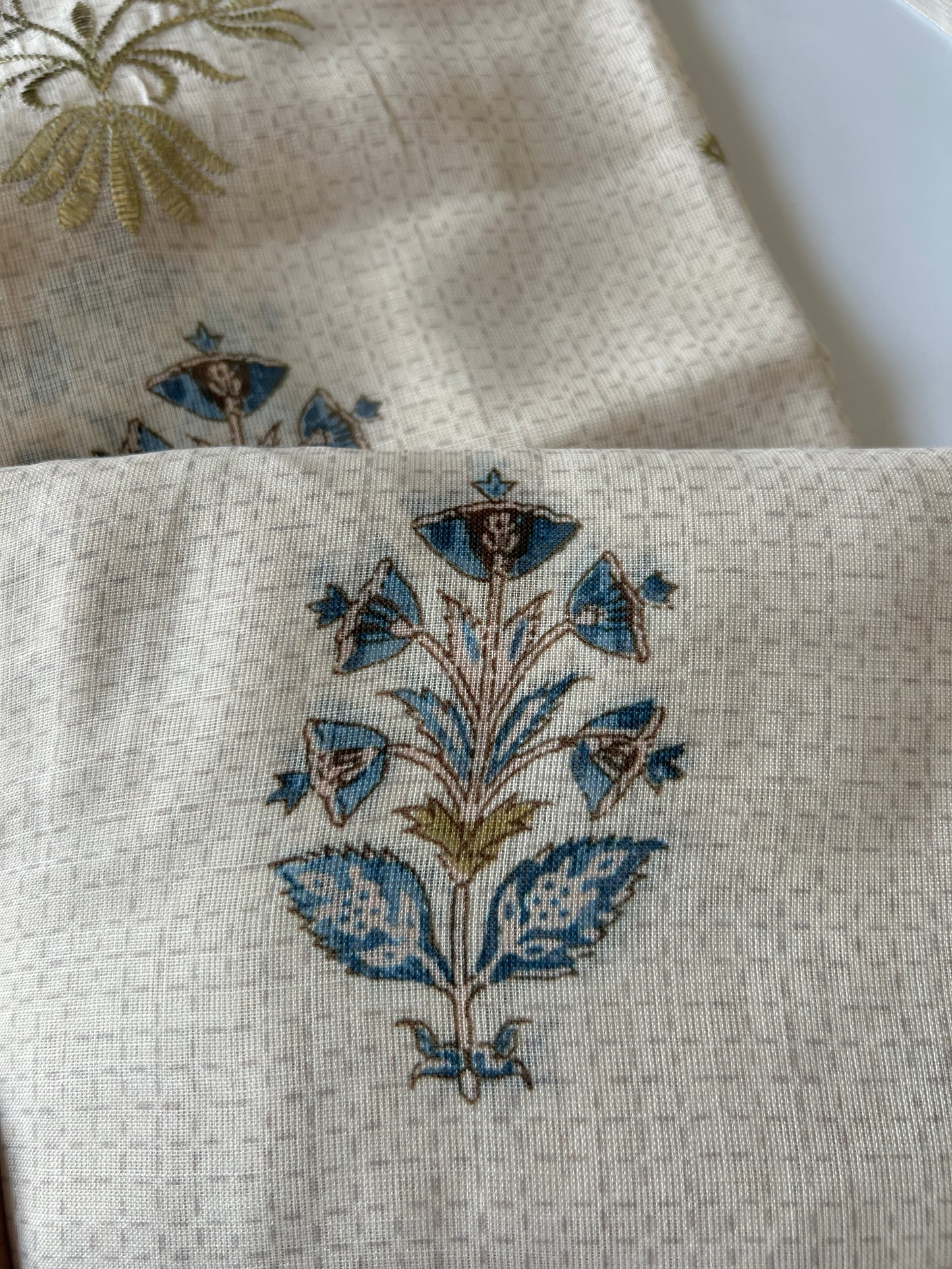 Elegant light cream dress material featuring traditional pitta work and soft breathable mul linen fabric