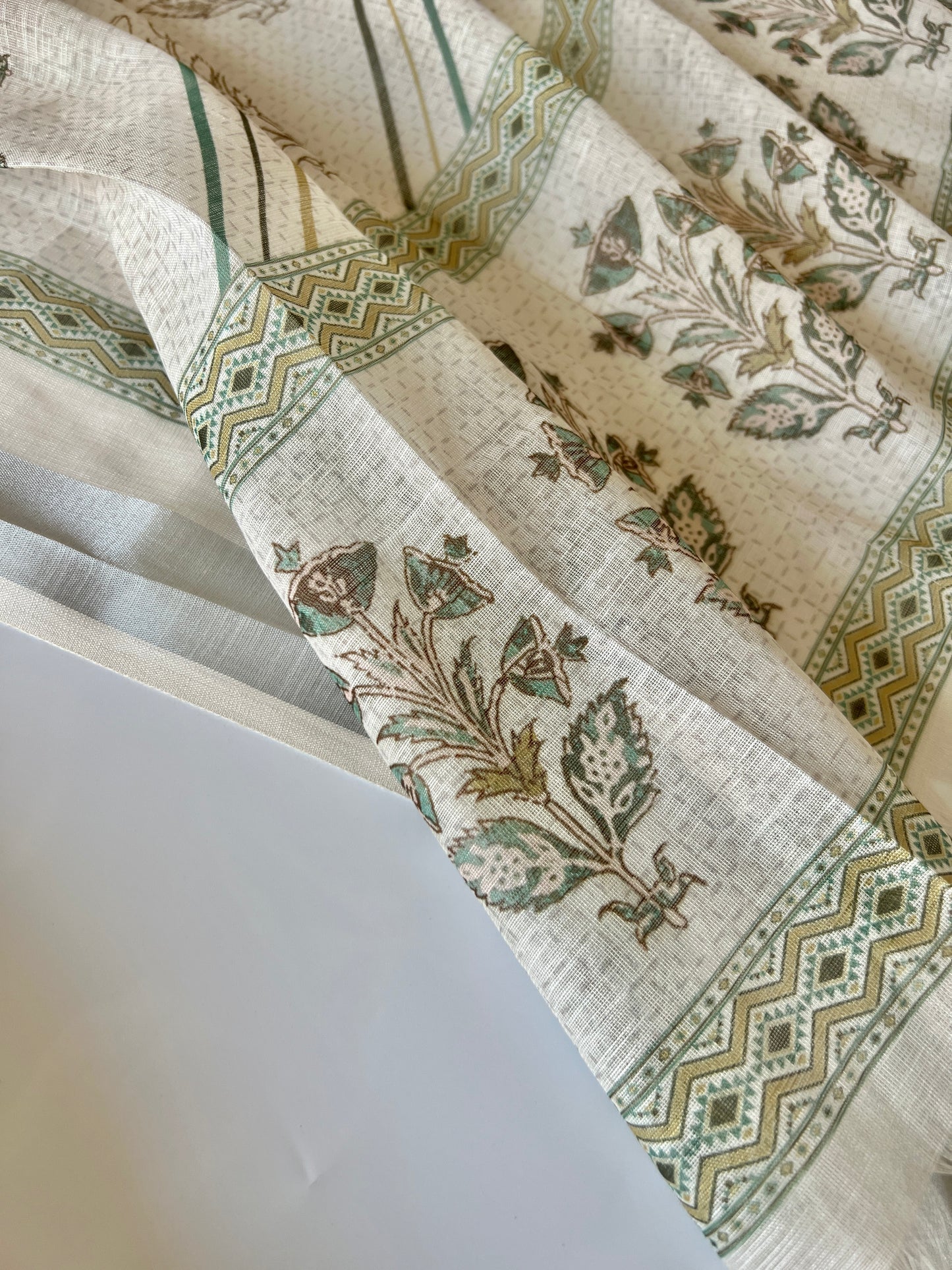 Premium cream mul linen dress material for women featuring subtle printed ethnic design and pitta detailing