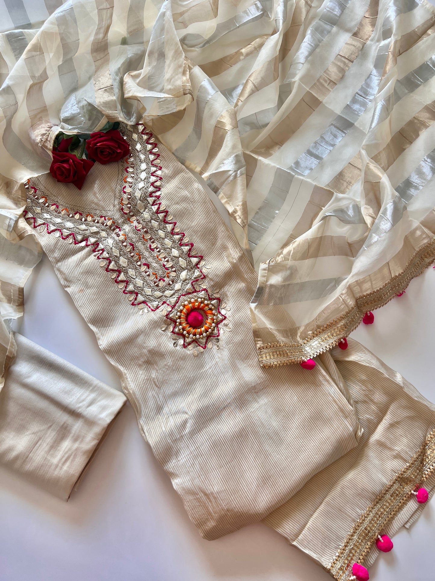 Premium cream tissue dress material with elegant neck embroidery and pom pom latkans for festive ethnic wear