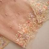 Close-up of floral embroidery unstitched suit on tissue fabric